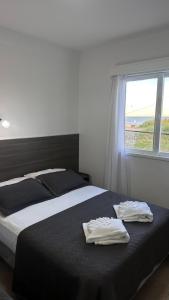 una camera da letto con un letto con due asciugamani sopra di Hotel Araucano a Mar de Ajó Altre 33 foto