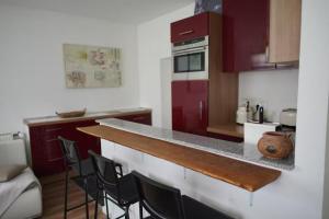 a kitchen with red cabinets and a counter with chairs at CALM HOME im Erdgeschoss mit eigenem Eingang in Bad Oeynhausen