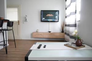 a living room with a couch and a tv on a wall at CALM HOME im Erdgeschoss mit eigenem Eingang in Bad Oeynhausen