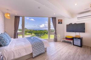una camera da letto con un letto grande e una grande finestra di 墾丁卿卿文旅 a Città Vecchia di Hengchun