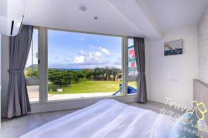 una camera da letto con una grande finestra con vista di 墾丁卿卿文旅 a Città Vecchia di Hengchun