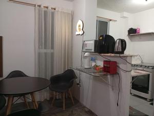 a small kitchen with a table and chairs in a room at Apartamento Serena in Votorantim