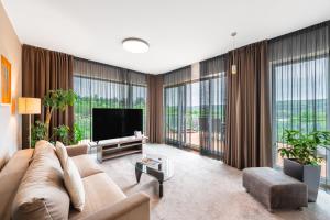 a living room with a couch and a flat screen tv at Maximus Resort in Brno