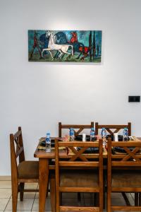 een houten tafel met stoelen en een schilderij aan de muur bij Modern 2BR Condo 10min from beach and Souk in Agadir