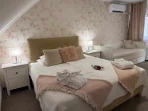 a bedroom with a large bed with two tables and lamps at Amfora Panzió in Gyula +74 photos