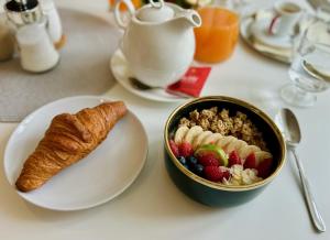 a table with a bowl of cereal and a bowl of fruit at Resort Červený dvůr - apartmány a wellness in Rapotín