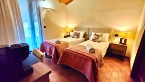 a bedroom with two beds and a large window at Agriturismo Lo Scalandrino in Grosseto
