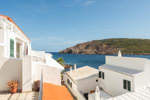 uitzicht op de oceaan vanaf de daken van witte gebouwen bij Apartamento Tramontana 28B in Fornells