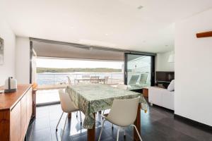 een keuken en eetkamer met een tafel en stoelen bij Apartamento Tramontana 28B in Fornells