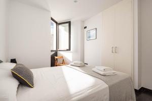 een witte slaapkamer met een bed met handdoeken erop bij Apartamento Tramontana 28B in Fornells