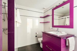 een paarse badkamer met een wastafel en een spiegel bij Apartamento Tramontana 28B in Fornells