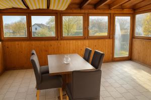 a dining room with a table and chairs and windows at GMA Apartment P8 in Lahr