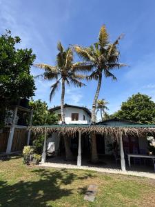 two palm trees in front of a house at Naïa Ocean House Midigama in Midigama West