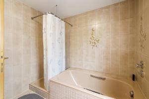 a bathroom with a white tub and a shower at GMA Apartment P8 in Lahr +31 photos