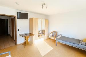 a bedroom with a bed and a table and a desk at GMA Apartment P8 in Lahr