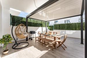 een eetkamer met een tafel, stoelen en ramen bij Casa Miramar Oak 47 in Fuengirola