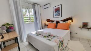 een kleine slaapkamer met een bed en een raam bij Le chant du Lagon in La Saline les Bains