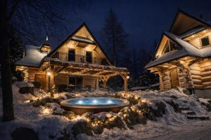 una baita di tronchi con vasca idromassaggio nella neve di Góralska Chatka jacuzzi i sauna a Kościelisko