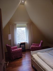 - une chambre avec deux chaises, un lit et une fenêtre dans l'établissement Haus Bei Der Kirche, à Oland