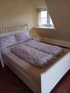 - une chambre avec un lit et une couverture fleurie dans l'établissement Haus Bei Der Kirche, à Oland