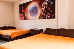 a room with two beds and a painting on the wall at hotel orkkowasi colca in Coporaque