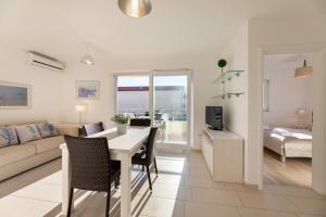 ein Wohnzimmer mit Tisch, Stühlen und Sofa in der Unterkunft Pansion Burin in Baška