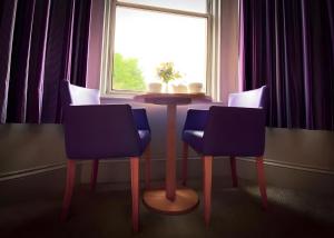 een tafel en stoelen in een kamer met een raam bij Tor Park Hotel in Torquay