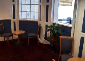 een kamer met een tafel, stoelen en een raam bij Tor Park Hotel in Torquay +5 foto's