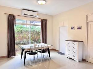 a dining room with a table and chairs and a window at Happy House Casa Seaside Rayong in Ban Chak Phai