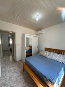 ein Schlafzimmer mit einem blauen Bett in einem Zimmer in der Unterkunft Casa Bombinhas Bombas beach in Bombinhas