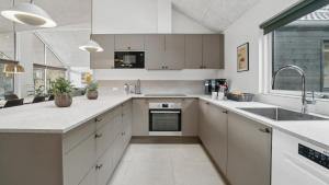 eine Küche mit weißen Schränken und einer Spüle in der Unterkunft Villavilla #621 - Dueodde, Bornholm in Vester Sømarken