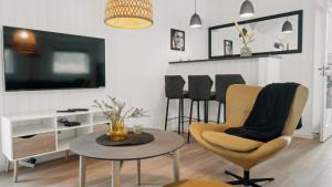 een woonkamer met een tafel en stoelen en een televisie bij Villavilla #622 - Dueodde, Bornholm in Vester Sømarken