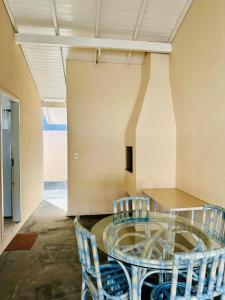 ein Esszimmer mit Glastisch und Stühlen in der Unterkunft Casa Bombinhas Bombas beach in Bombinhas