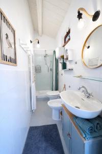 een badkamer met een wastafel, een toilet en een spiegel bij fattoria Coppetella Cemani in Molino dʼAgugliano +13 foto's