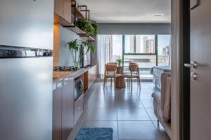 een keuken met uitzicht op een tafel met stoelen bij ICON - Vista Mar Boa Viagem in Recife