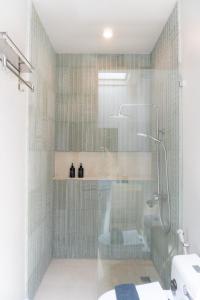 a bathroom with a shower with a glass door at Villa IKIN in Lovina
