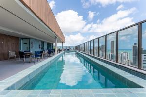 een zwembad in een gebouw met uitzicht op de oceaan bij ICON - Vista Mar Boa Viagem in Recife