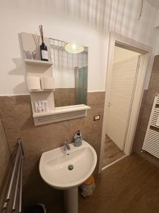 ein Badezimmer mit Waschbecken und Spiegel in der Unterkunft Nottetempo in Cesena