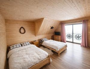 una camera da letto con due letti e una grande finestra di Góralska Chatka jacuzzi i sauna a Kościelisko