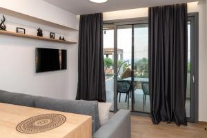un soggiorno con un divano e un tavolo di Enalis Studios & Apartments a Karfás