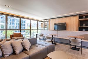 een woonkamer met een bank en tafels bij ICON - Vista Mar Boa Viagem in Recife