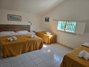 a hotel room with two beds and a window at Hotel Marittimo in Rimini
