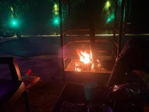 een vuurplaats 's nachts met twee groene lampen bij The Paradise farm stay in Ghaziabad