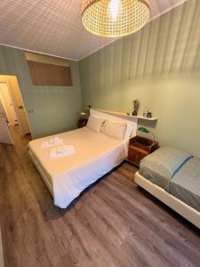 ein Schlafzimmer mit einem großen weißen Bett und einer Lampe in der Unterkunft Nottetempo in Cesena