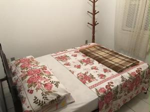 Bett mit Blumenbettdecke auf einem Zimmer in der Unterkunft Casa ampla no centro Barra Velha in Barra Velha + 6 Fotos