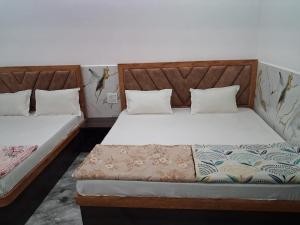 1 Schlafzimmer mit 2 Betten in der Unterkunft Prabhu Kripa Dham Guest House in Jāmb