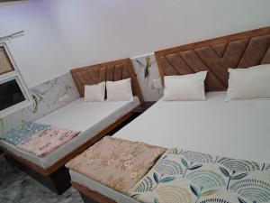 zwei Betten nebeneinander in einem Zimmer in der Unterkunft Prabhu Kripa Dham Guest House in Jāmb