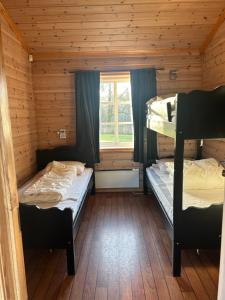 2 stapelbedden in een hut met een raam bij Holmfoss Hytta in Larvik