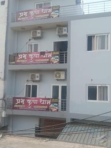 ein weißes Gebäude mit Schildern an der Seite in der Unterkunft Prabhu Kripa Dham Guest House in Jāmb