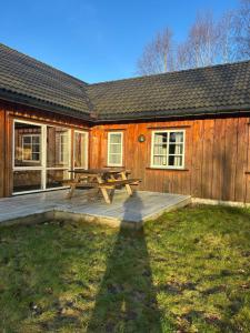 een houten hut met een picknicktafel in de tuin bij Holmfoss Hytta in Larvik